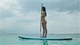 Disha Patani looks smoking hot and sexyin a yellow bikini as she strikes a pose on the surfboard