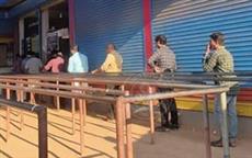 Drinkers Line up at a Liquor Store