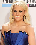 Carrie Underwood poses backstage with the favorite country music album award at the 40th American Music Awards in Los Angeles