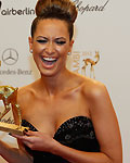 German singer Mandy Capristo displays a fake bambi award that she braught with herself as she arrives for the 64th Bambi media awards ceremony in Duesseldorf