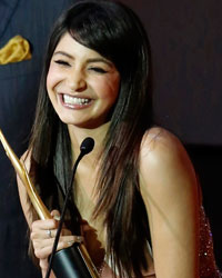 Anushka Sharma smiles after receiving an award for the best performance in a supporting role from actress Sridevi as producer Boney Kapoor watches at the 14th annual International Indian Film Academy (IIFA) awards show in Macau