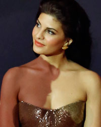Abhishek Bachchan holds the trophy after winning the award for the best performance in a comic role as actress Jacqueline Fernandez watches at the 14th annual International Indian Film Academy (IIFA) awards show in Macau