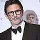 Director and writer Michel Hazanavicius celebrates after winning the award for original screenplay for The Artist at the BAFTA awards ceremony
