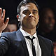 Robbie Williams acknowledges the applause at the Brit Awards ceremony in London