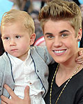 Justin Bieber carries his younger brother Jaxon as he arrives for the MuchMusic Video Awards in Torontoto