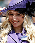 A dress code attendant adjusts her hat as she stands on duty at the entrance on the first day's of Royal Ascot, southwest of London