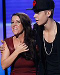 Justin Bieber accepts the award for artist of the year with his mother Pattie Mallette at the 40th American Music Awards in Los Angeles