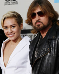 Entertainer Wayne Newton, singer Miley Cyrus and her father Billy Ray Cyrus (R) arrive at the 41st American Music Awards in Los Angeles