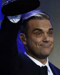 British singer Robbie Williams holds up his trophy for Entertainment during the Bambi 2013 media awards ceremony in Berlin