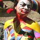 A model walks past an artist applying the finishing touches to a model before the start of a body art contest in the Black Sea port of Odessa.