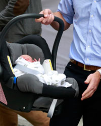 Britain's Prince William carries his baby son in a car seat, as he leaves the Lindo Wing of St Mary's Hospital with his wife Catherine, Duchess of Cambridge, in central London