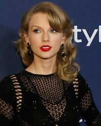 Singer Taylor Swift poses at the 15th annual Warner Bros. and InStyle after party, after the 71st annual Golden Globe Awards in Beverly Hills, California