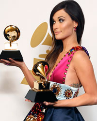 Country singer Kacey Musgraves poses backstage with her awards for Best Country Song for 'Merry Go 'Round' and Best Country Album for 'Same Trailer Different Park' at the 56th annual Grammy Awards in Los Angeles, California