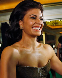 Jacqueline Fernandez smiles while speaking to reporters on the green carpet before the 14th annual International Indian Film Academy (IIFA) awards show in Macau