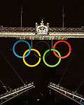 The Olympic rings hang on London's Tower Bridge as a speedboat driven by Britain's David Beckham and carrying the Olympic torch prepares to mark the opening ceremony of the 2012 Olympic Games