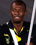 Jamaica's flag bearer Usain Bolt holds the national flag as he leads the contingent in the athletes parade during the opening ceremony of the London 2012 Olympic Games at the Olympic Stadium