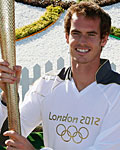 Britain's Andy Murray poses with the Olympic Torch on Murray Mound at the All England Lawn Tennis Club before the start of the London 2012 Olympic Games in London