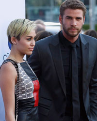 Cast member Liam Hemsworth poses with his fiancee, singer Miley Cyrus, at the premiere of 'Paranoia' in Los Angeles, California