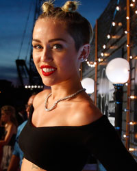 Singer Miley Cyrus poses as she arrives for the 2013 MTV Video Music Awards in New York