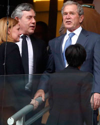 Former U.S. President George W. Bush (top R) talks to former British Prime Minister Gordon Brown (top L) as they attend the memorial service for late South African President Nelson Mandela at the First National Bank soccer stadium