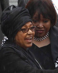 Winnie Mandela (L), ex-wife of former South African President Nelson Mandela, chats with former Archbishop Desmond Tutu during the national memorial service for Nelson Mandela at the First National Bank (FNB) Stadium