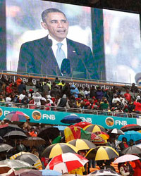 South Africans brave the rain as they listen to U.S. President Barack Obama speak during a memorial service for Nelson Mandela at FNB Stadium in Johannesburg