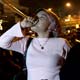 An Indonesian woman blows a paper trumpet to celebrate the New Year in Jakarta