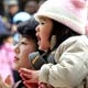 A Japanese girl and her parents pray at Meiji Shrine in Tokyo