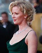 Hugh Jackman of the film 'Les Miserables' talks to photographers as actress Gretchen Mol of the TV series 'Boardwalk Empire' poses beside him at the 19th annual Screen Actors Guild Awards