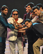 L to R- Prasenjit Chatterjee receiving the award Surachitrak Prasenjit from Bappi Lahiri, Bappa Lahiri, Jeet, Rudranil, Parombrato and Anupam at the Mirchi Music Award