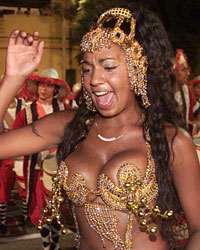 A woman dances a candombe as men play the drums during the 'llamadas' parade in Montevideo