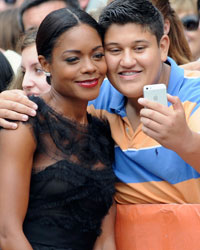 Cast member Naomie Harris poses with a fan on the red carpet before a screening of the film 'Mandela: Long Walk to Freedom' at Roy Thomson Hall during the 38th Toronto International Film Festival