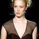 Racquel wears a chocolate chiffon and red silk jacquard dress at the showing of the Luca Luca Fall 2005 collection.