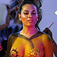 Artists apply body paint on a model during Santander Fashion Week Bucaramanga