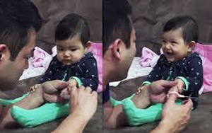 Cute baby pretends to cry as dad cuts her nails